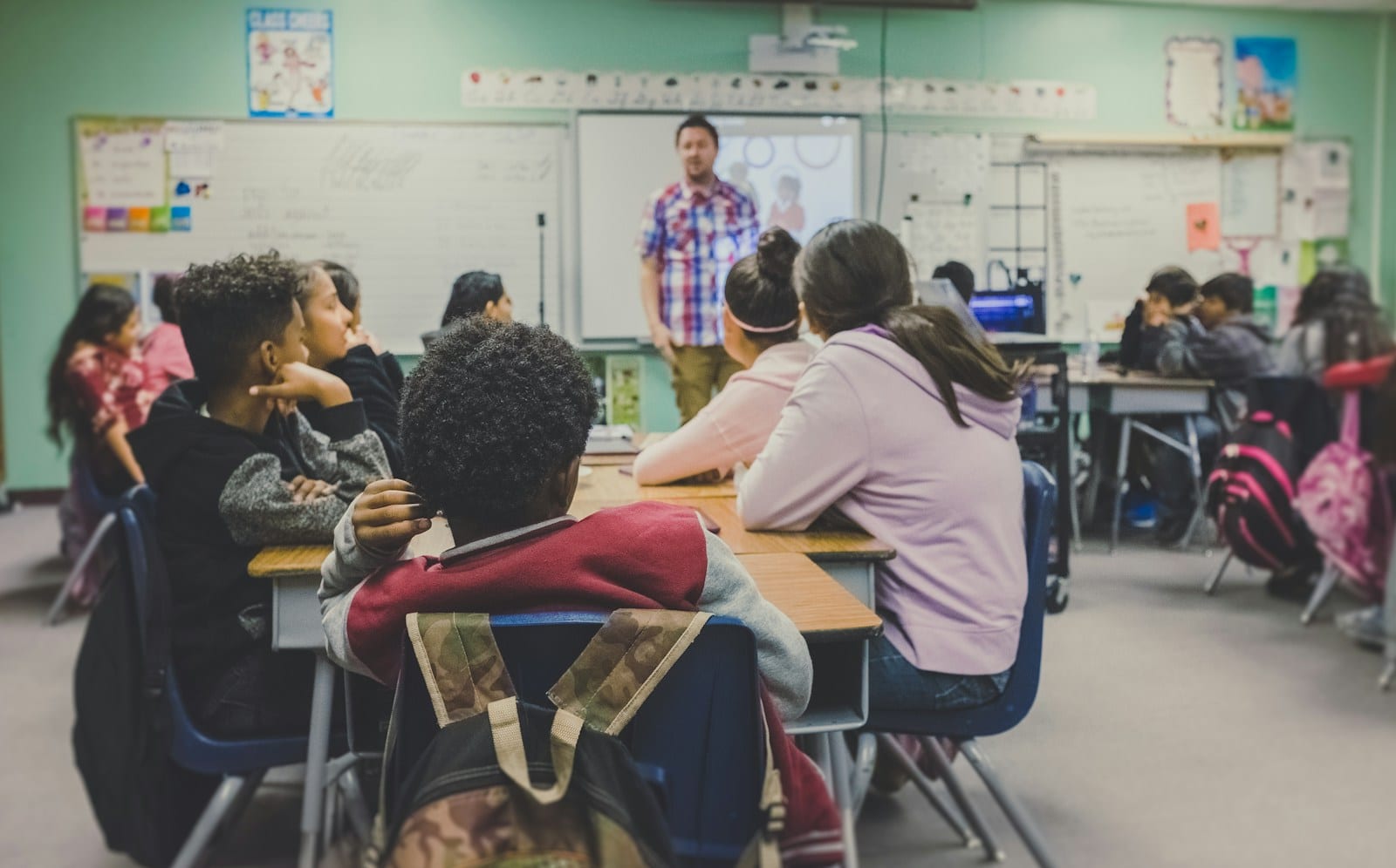 A teacher and students learning together in a bright classroom